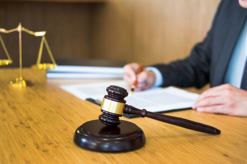 lawyer judge reading documents at desk in courtroom working on wooden desk background